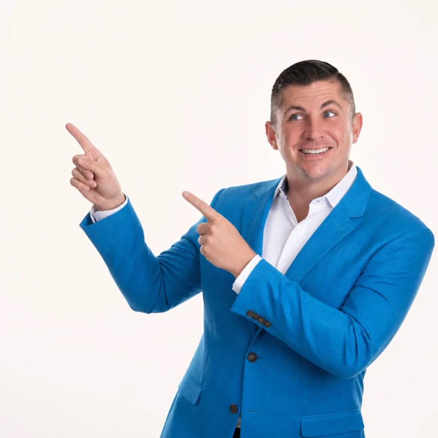 Rennie Barton grinning and pointing up and left with both hands